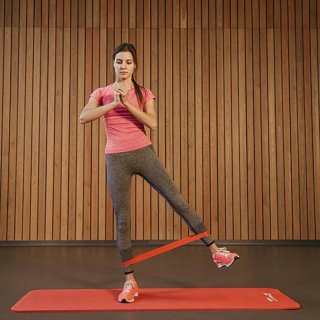 Mujer haciendo ejercicio con una banda de resistencia. 