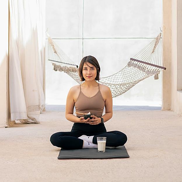Mujer meditando sobre esterilla. 