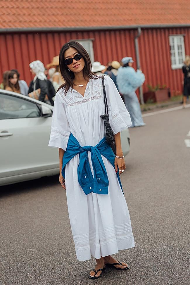 Un look con vestido blanco y sandalias negras.
