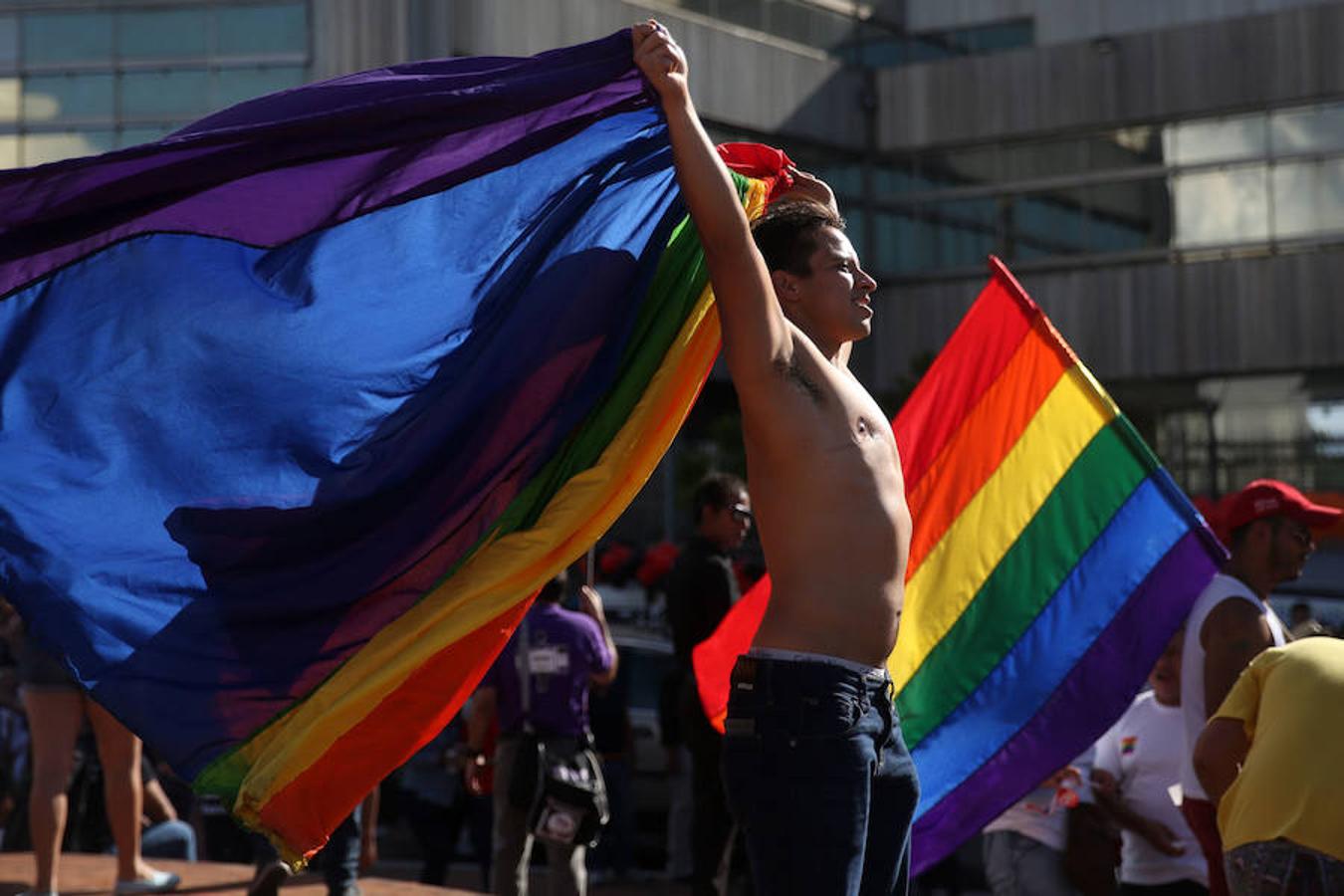 Un joven ondea una bandera de color arcoiris a modo de capa durante la Marcha del Orgullo Gay en Guatemala.