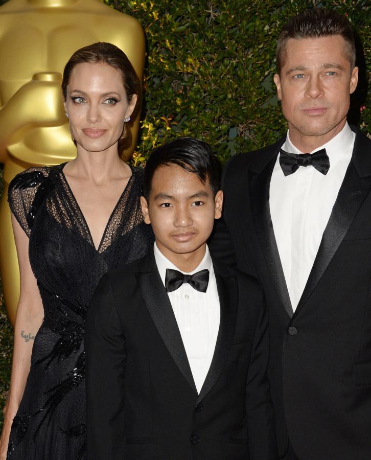 Angelina Jolie y Brad Pitt posando junto a su hijo Maddox Jolie-Pitt en los premios Governors de 2013.