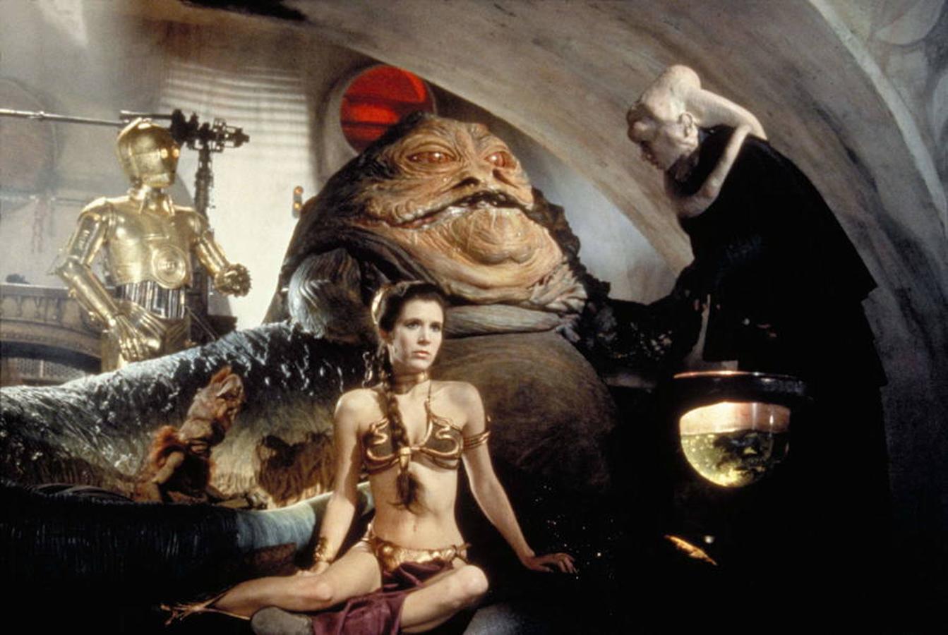 Carrie Fisher, en una de las imágenes más icónicas de 'El retorno del Jedi', cuando es apresada por Jabba el Hutt.