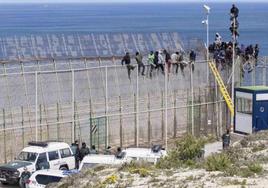 Inmigrantes encaramados a la valla de Melilla, en una imagen de archivo.