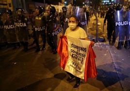 Una manifestante reclama en Lima el cierre del Congreso.