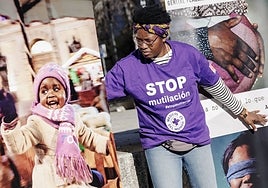 Una activista de MDM coloca fotografías contra la mutilación genital femenina