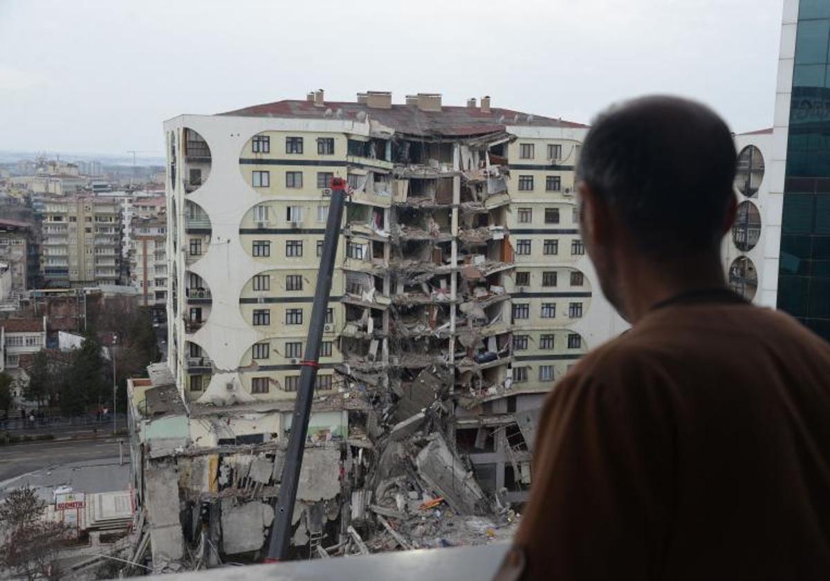 Un hombre observa las operaciones de búsqueda entre los restos de un edificio en Diyarbakir (Turquía)