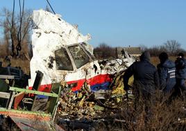 Trabajadores locales transportan restos del fuselaje del avión de Malaysian Airlines, en una imagen de archivo