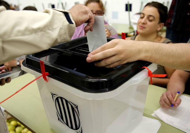 Un ciudadano deposita su voto para el referéndum indepedentista