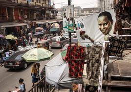 La propaganda electoral convive con los puestos de venta en un mercado de Lagos.