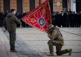 Zelenski sujeta la bandera durante una ceremonia militar celebrada ayer en Kiev