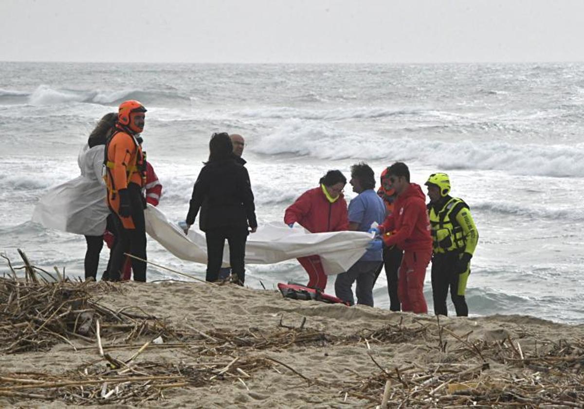 Los equipos de rescate cubren uno de los cadáveres encontrados en la playa de Cutro.