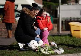 Una mujer y su hija depositan flores cerca del lugar donde fue hallado sin vida el bebé en Brighton