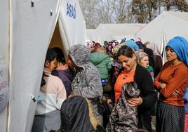 Víctimas del terremoto hacen cola para recibir ayuda en un campamento de tiendas de campaña en la localidad turca de Kahramanmaras.