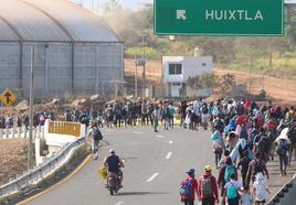 Migrantes caminan por una carretera de la ciudad de Huixtla, en el sur de México, con destino a la frontera con Estados Unidos