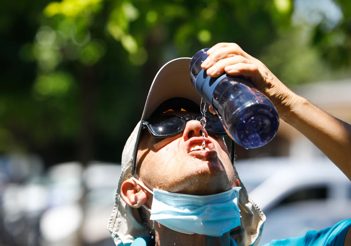 Un turista se refresca en un día caluroso en Córdoba.