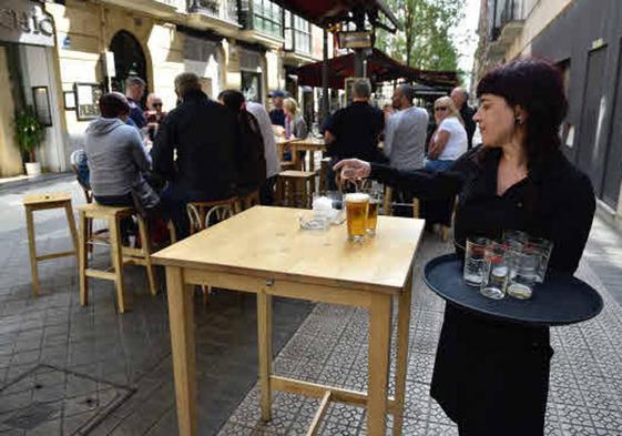 Una camarera sirviendo en una terraza.