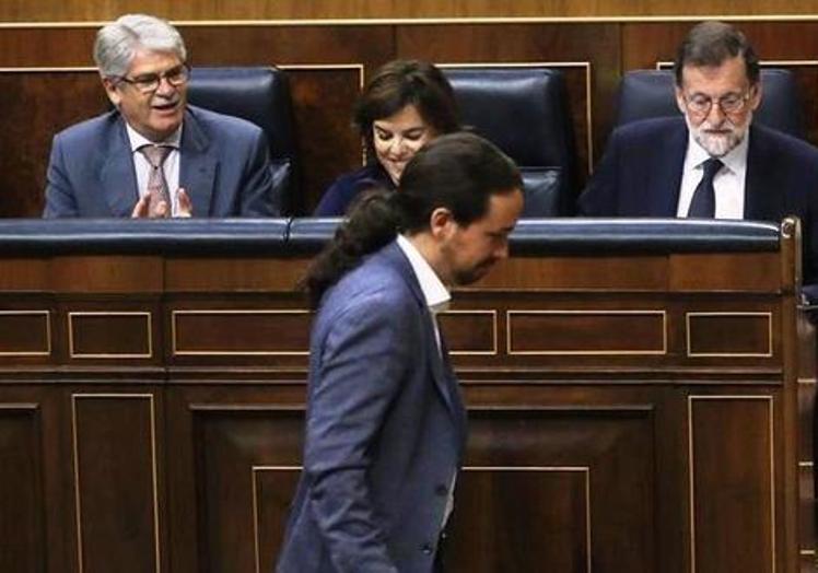 Iglesias pasa por delante del escaño de Rajoy antes de su debate en la moción de censura.