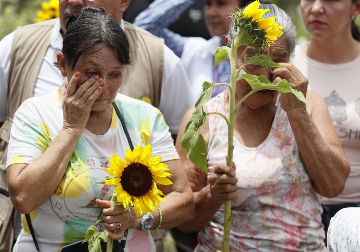 Dos mujeres participan en un homenaje a víctimas de desaparición forzada durante el conflicto armado en Colombia