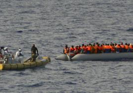 Una lancha de la Armada italiana se aproximan a un bote neumático lleno de inmigrantes cerca de la costa de Lampedusa