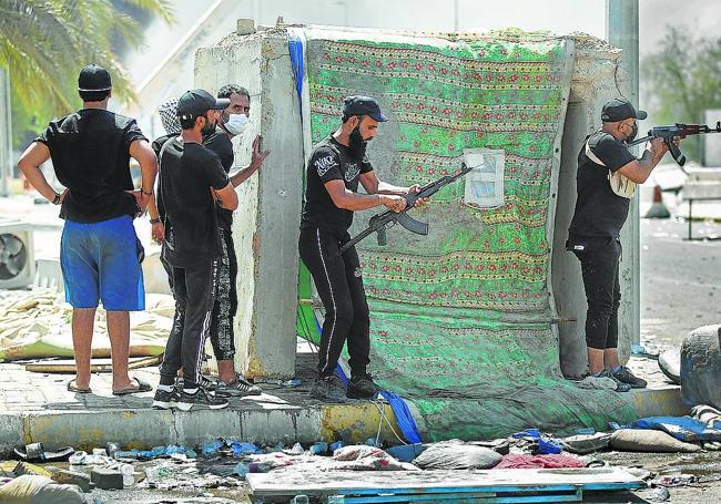 Miembros armados de una brigada chiíta son fotografiados durante enfrentamientos con las fuerzas de seguridad iraquíes en la Zona Verde de Bagdad el 30 de agosto de 2022.