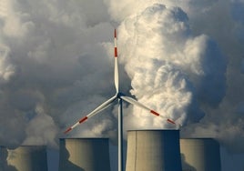 Aerogenerador ante las chimeneas de una planta de lignito en Jaenschwalde (Alemania).