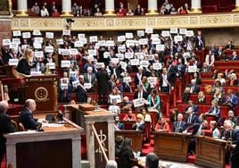 Los integrantes de La Francia Insumisa y de la coalición de izquierda Nupes protestan con carteles durante la votación de la moción de censura en la Asamblea Nacional.