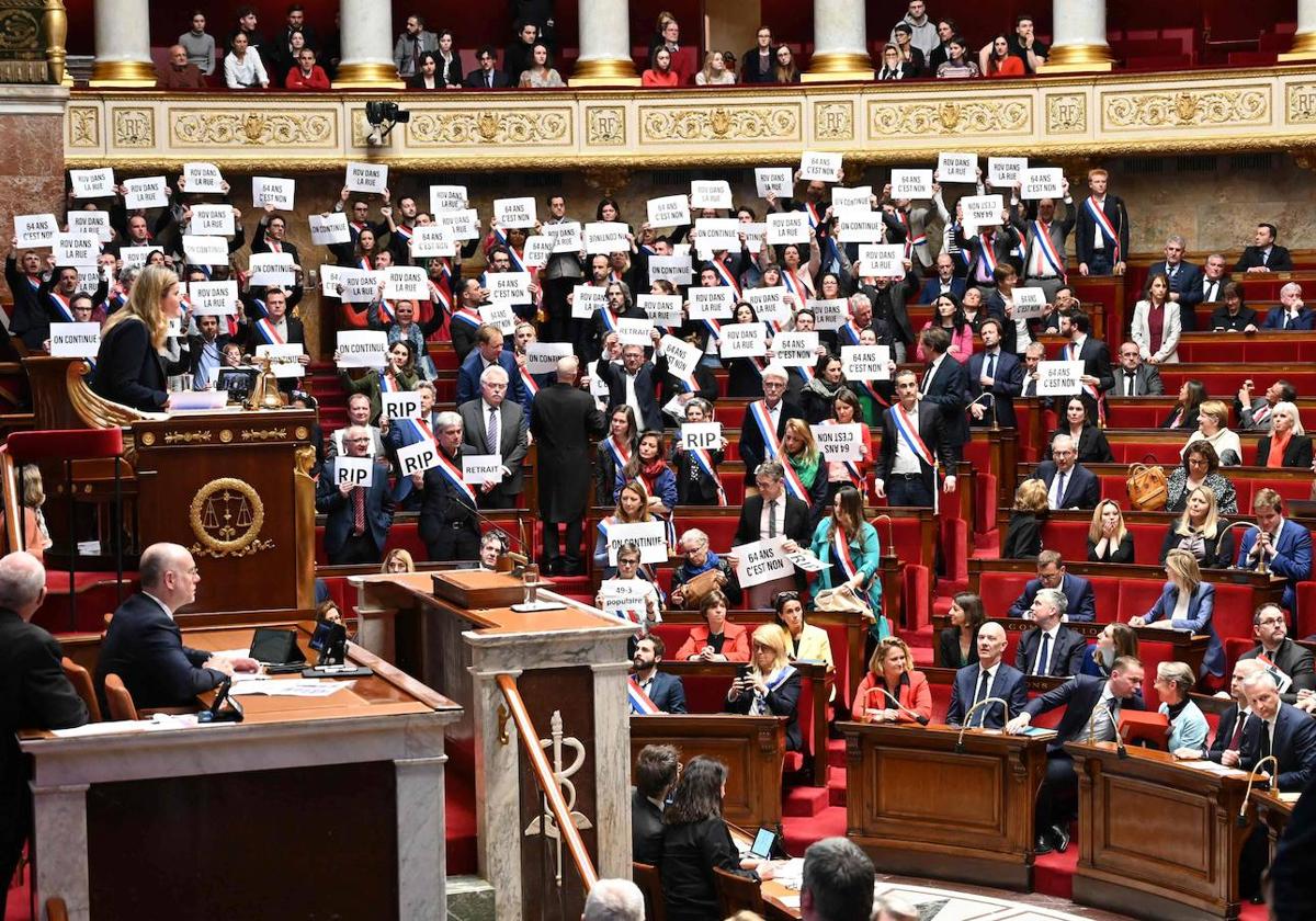 Los integrantes de La Francia Insumisa y de la coalición de izquierda Nupes protestan con carteles durante la votación de la moción de censura en la Asamblea Nacional.