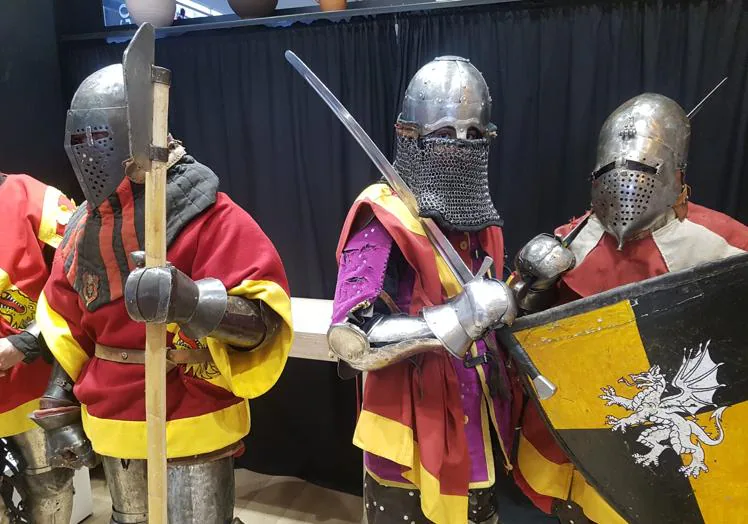 Imagen principal - Tres combatientes medievales; el grupo con los organizadores y la poeta Virginia Gutiérrez que luchará en la modalidad de duelo.