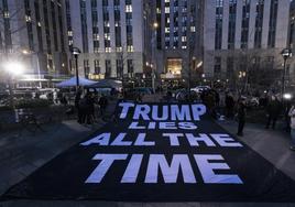 Opositores al expresidente desplegaron anoche una pancarta frente a la sede judicial con la frase 'Trump miente todo el tiempo'