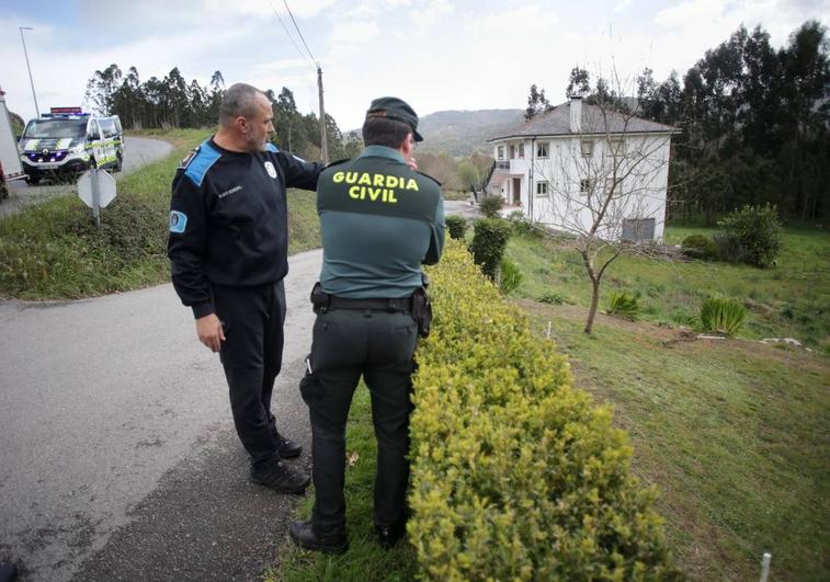 Efectivos de Guardia Civil y Policía investigan la zona por donde cayó el coche del accidente en Xove (Lugo).