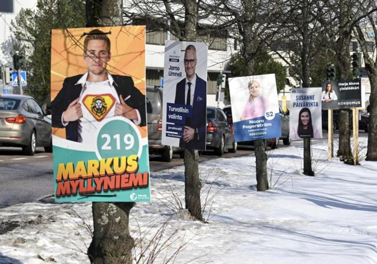 Carteles electorales de varios partidos llaman al voto de sus candidatos al lado de una carretera en una localidad finlandesa.