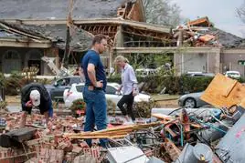 Una familia busca sus pertenencias entre los escombros de un edificio destruido en Arkansas.