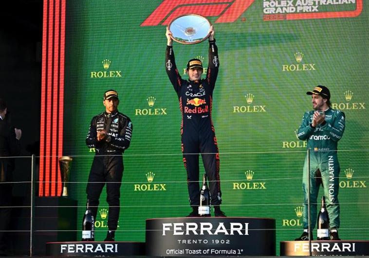 Max Verstappen levanta el trofeo que le acredita como ganador del GP de Australia en un podio completado por Lewis Hamilton y Fernando Alonso.