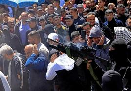 Un miliciano dispara al aire durante el funeral de dos palestinos muertos en una redada del ejército israelí en Cisjordania.