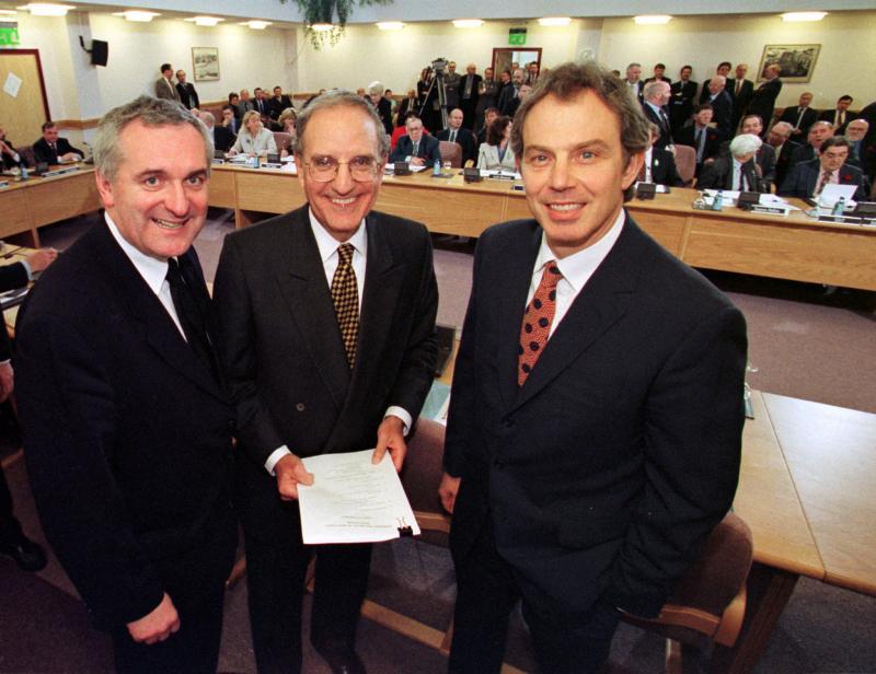 El primer ministro británico Tony Blair (derecha), el senador estadounidense George Mitchell (centro), y el primer ministro de Irlanda, Bertie Ahern, durante la firma del documento el 10 de abril de 1998