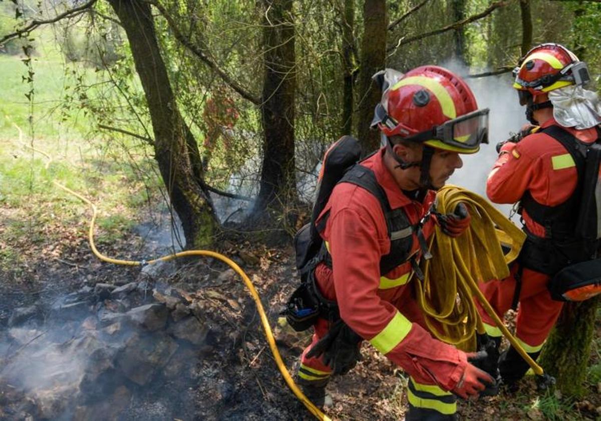 Dos efectivos de la Unidad Militar de Emergencias (UME), ayer, colaborando en la extinción del incendio de Las Regueras.