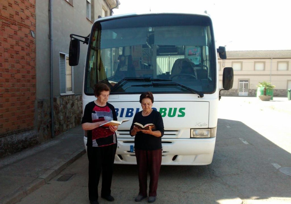 Dos vecinas de un pueblo de León ante el bibliobús que les ha traído las novelas soliciadas.