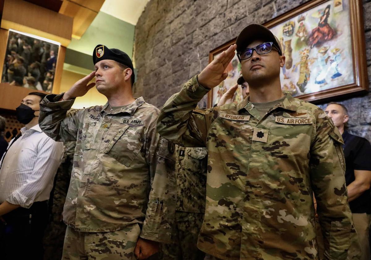 Dos soldados del ejército y la Fuerza Aérea de Estados Unidos saludan durante la ceremonia de apertura del 'Balikatan' en Quezon, en Filipinas