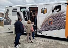 Usuarios de un bibliobús de Palencia aguardan su turno.