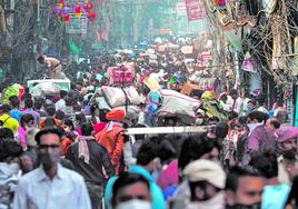 Decenas de personas caminan por una calle de Nueva Delhi, la capital de India.