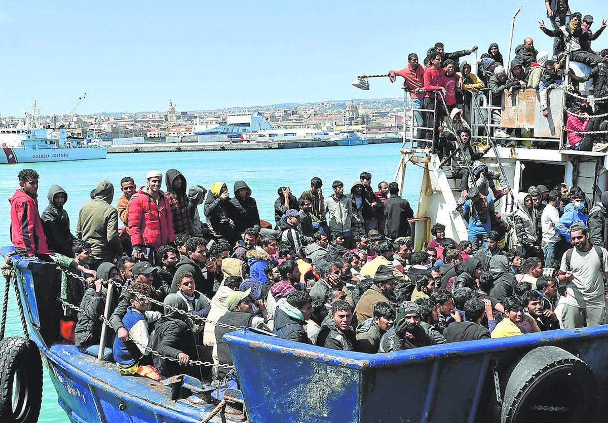 Crisis migratoria. Una embarcación con decenas de personas a bordo llega al puerto siciliano de Catania.