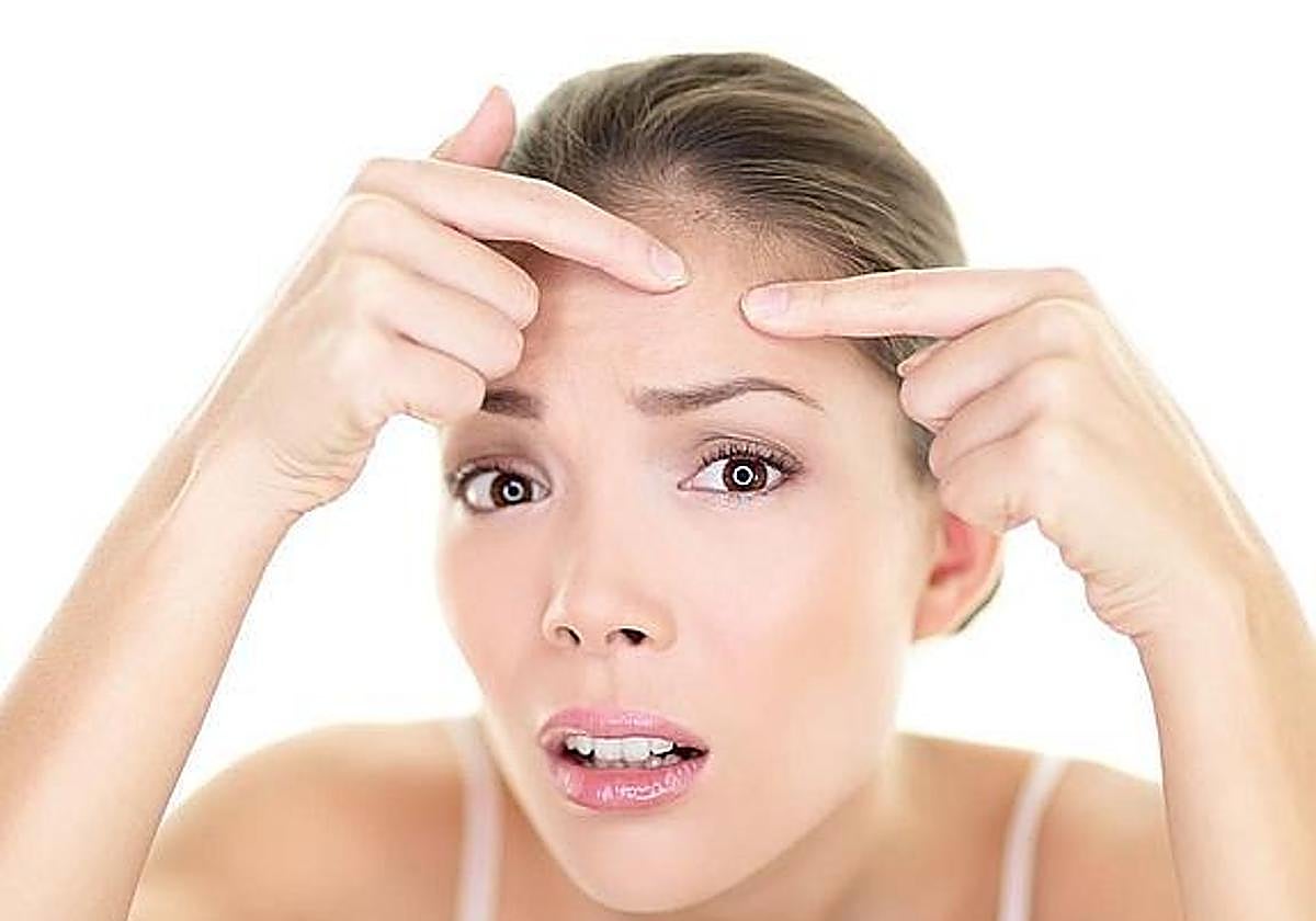 Una mujer se mira al espejo.