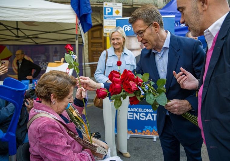 Alberto Núñez Feijóo entrega este domingo una rosa a una visitante a la Feria de Sant Jordi.