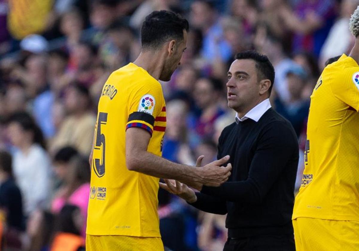 Xavi Hernandez dialoga con Sergio Busquets durante el duelo ante el Atlético.