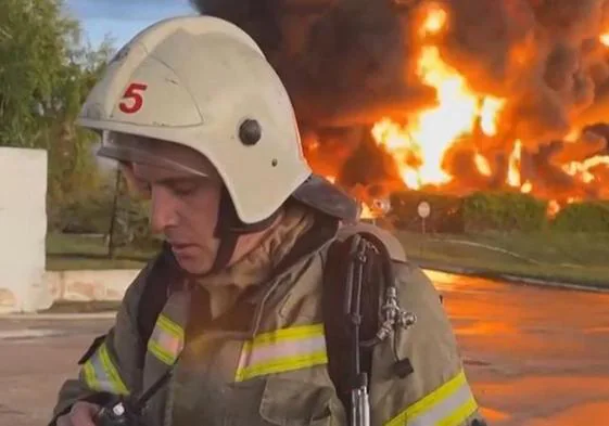 Los depósitos de combustible arden a espaldas de un bombero en el puerto de Sebastopol.