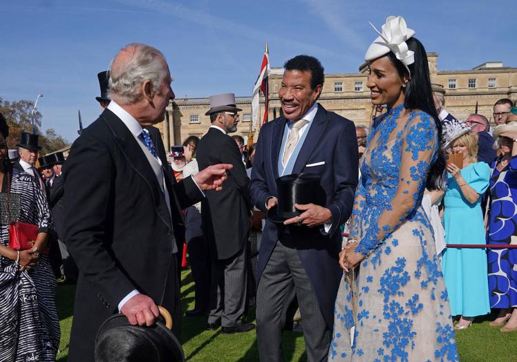 El rey saluda a Lionel Richie y su esposa en los jardines de Buckingham donde el miércoles se celebró una fiesta.