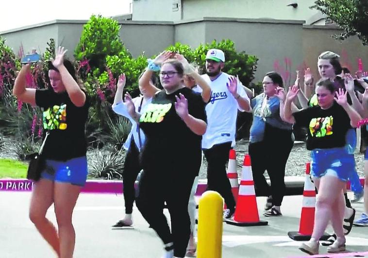 Las personas que se encontraban en el centro comercial salen con las manos en alto. .