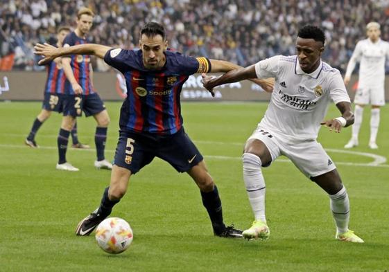 Sergio Busquets pugna con Vinicius en un clásico.