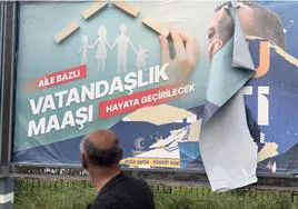 Un hombre camina por una calle de Diyarbakir en la que ha sido arrancado un cartel electoral de Erdogan.
