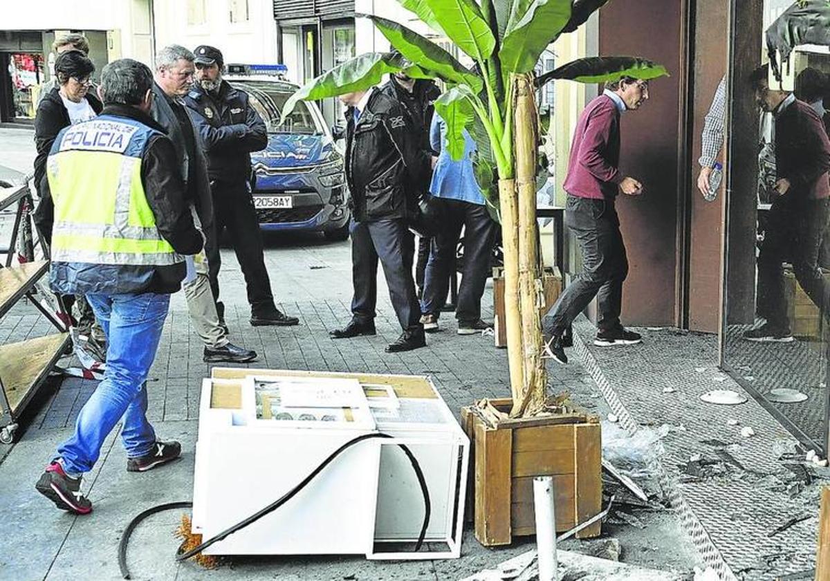 Vista del exterior de la pizzeria incendiada en Madrid el pasado 21 de abril el día después del suceso, cuando lo visitó el alcalde de Madrid, José Luis Martínez-Almeida (derecha).